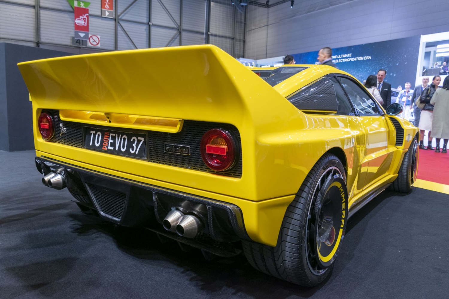 Rear view with wide body, large rear wing, dual exhaust pipes