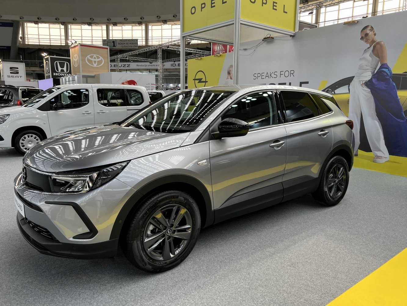 Front and side view of a modern silver SUV with sleek headlights and alloy wheels