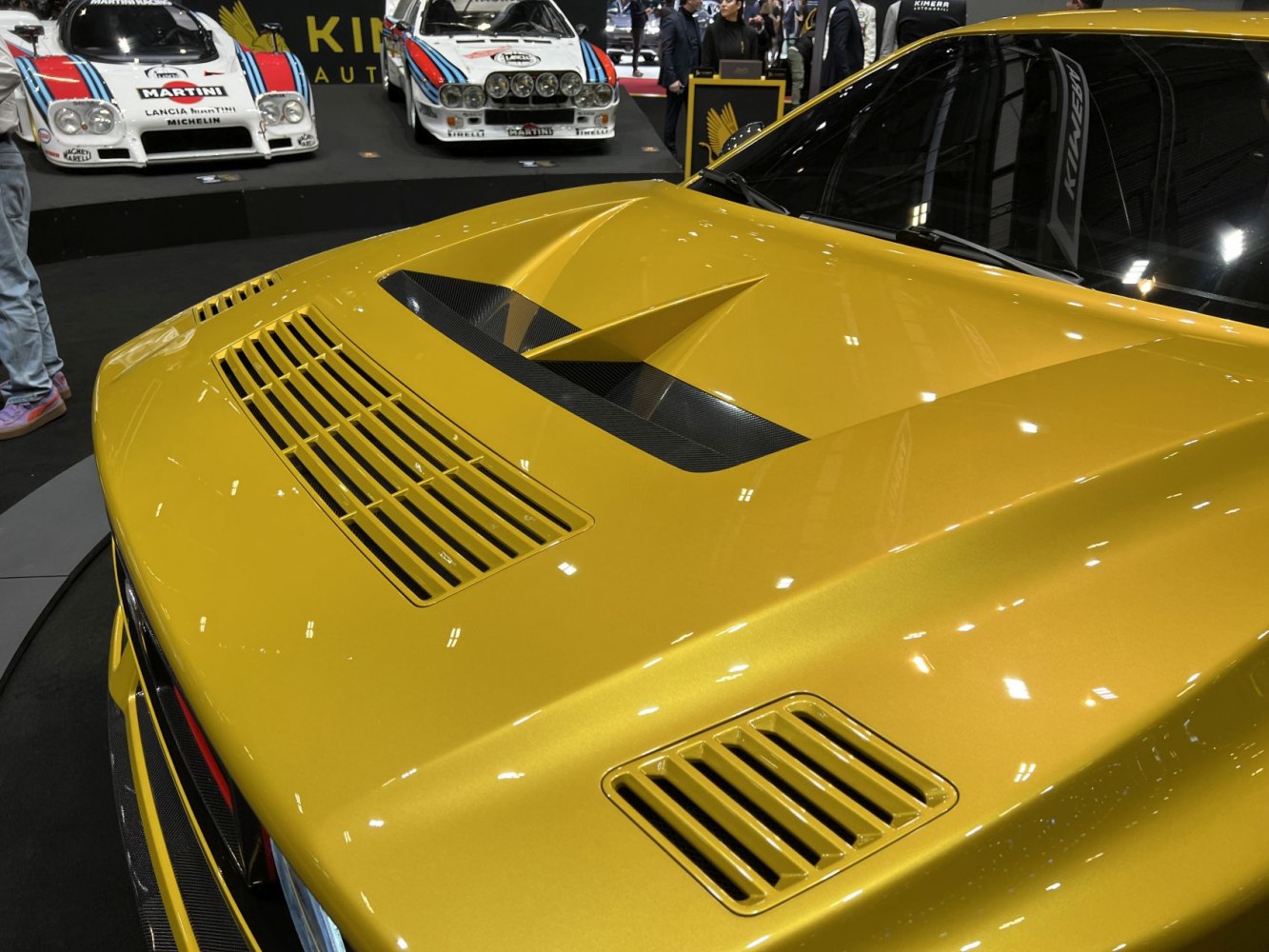 Close-up of yellow front hood with carbon fiber air vents and aerodynamic styling