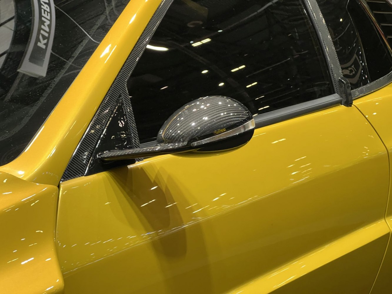Carbon fiber side mirror and window trim on yellow car door