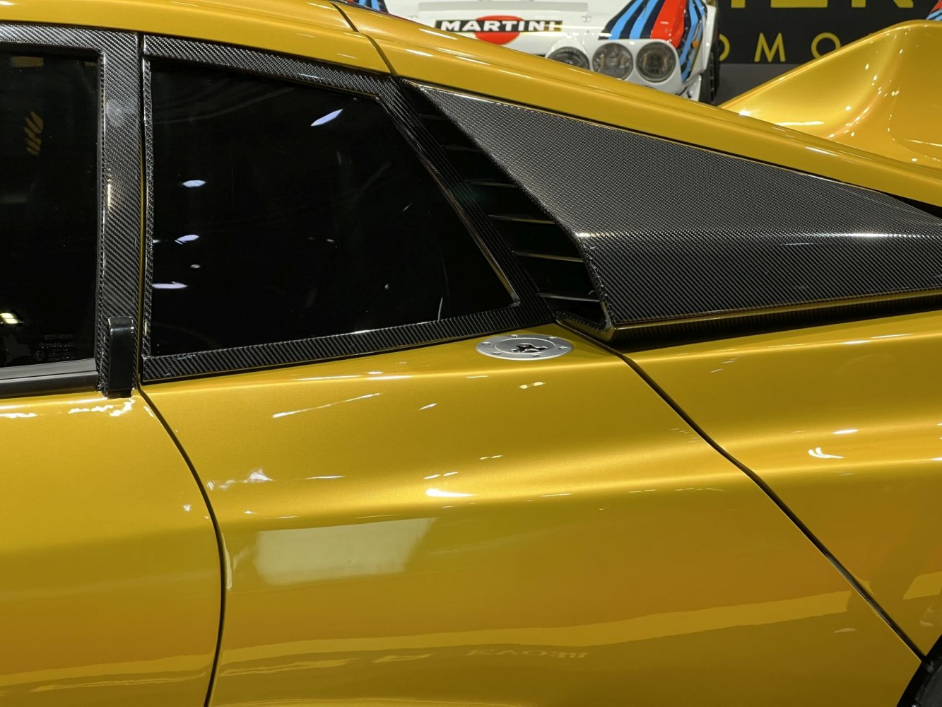 Side carbon fiber aerodynamic vent and fuel cap on yellow car panel