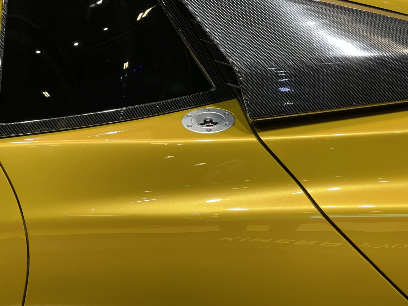 Carbon fiber roof panel and metallic fuel cap on yellow body.