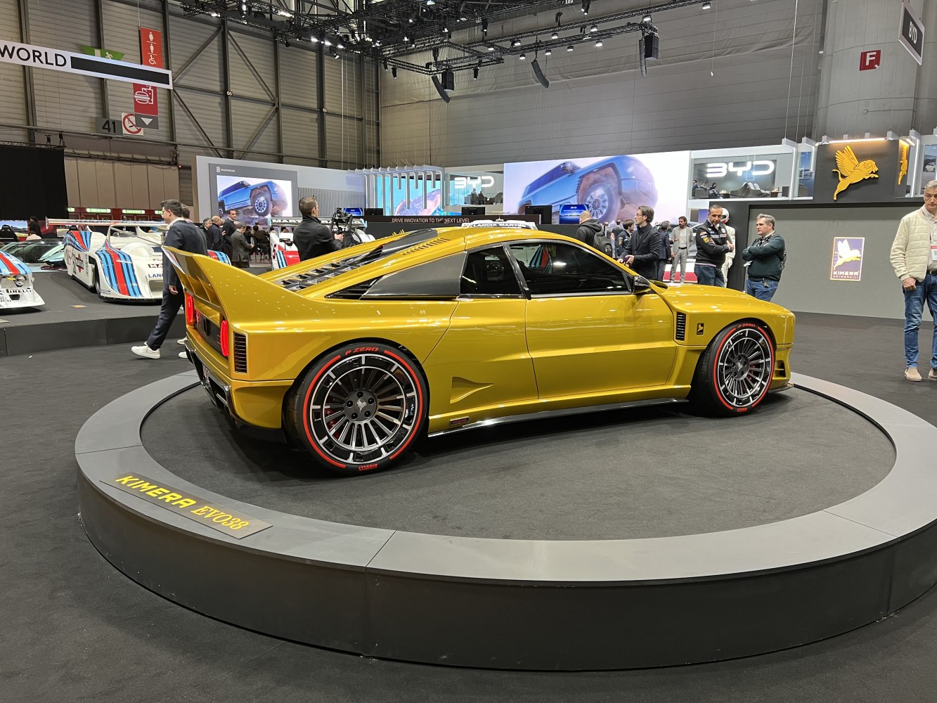 Yellow sports coupe with large rear wing and red-accented Pirelli tires