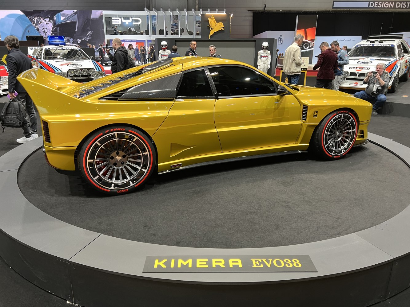 Side view of a sports coupe with large rear wing and multi-spoke alloy wheels with red-accented tires