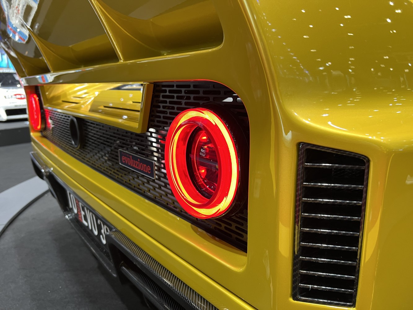 Circular rear tail light with rear vent on yellow car body