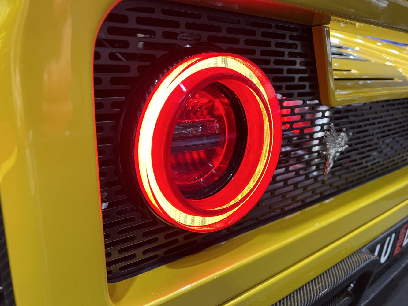 Close-up of circular LED tail light and rear grille detail