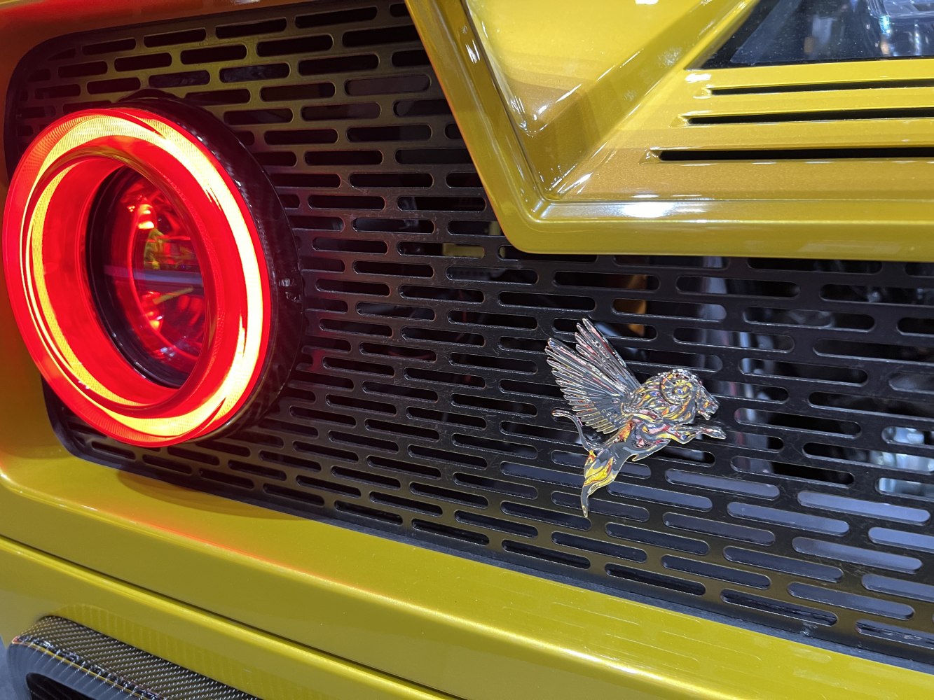 Rear light with a circular LED and flying lion emblem on rear grille