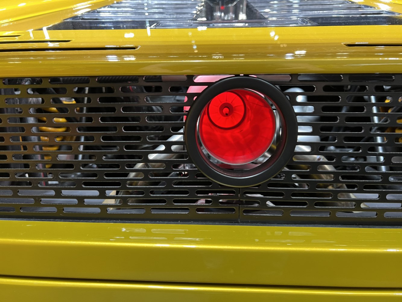 Central red circular exhaust with rear ventilation grille on yellow panel