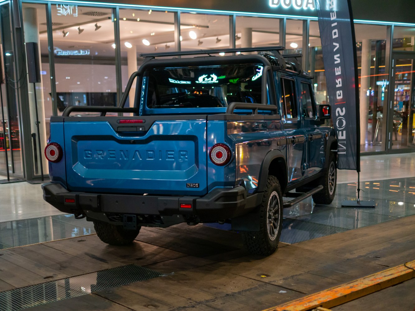 Rear view of a rugged pickup truck with round taillights and roof rack.