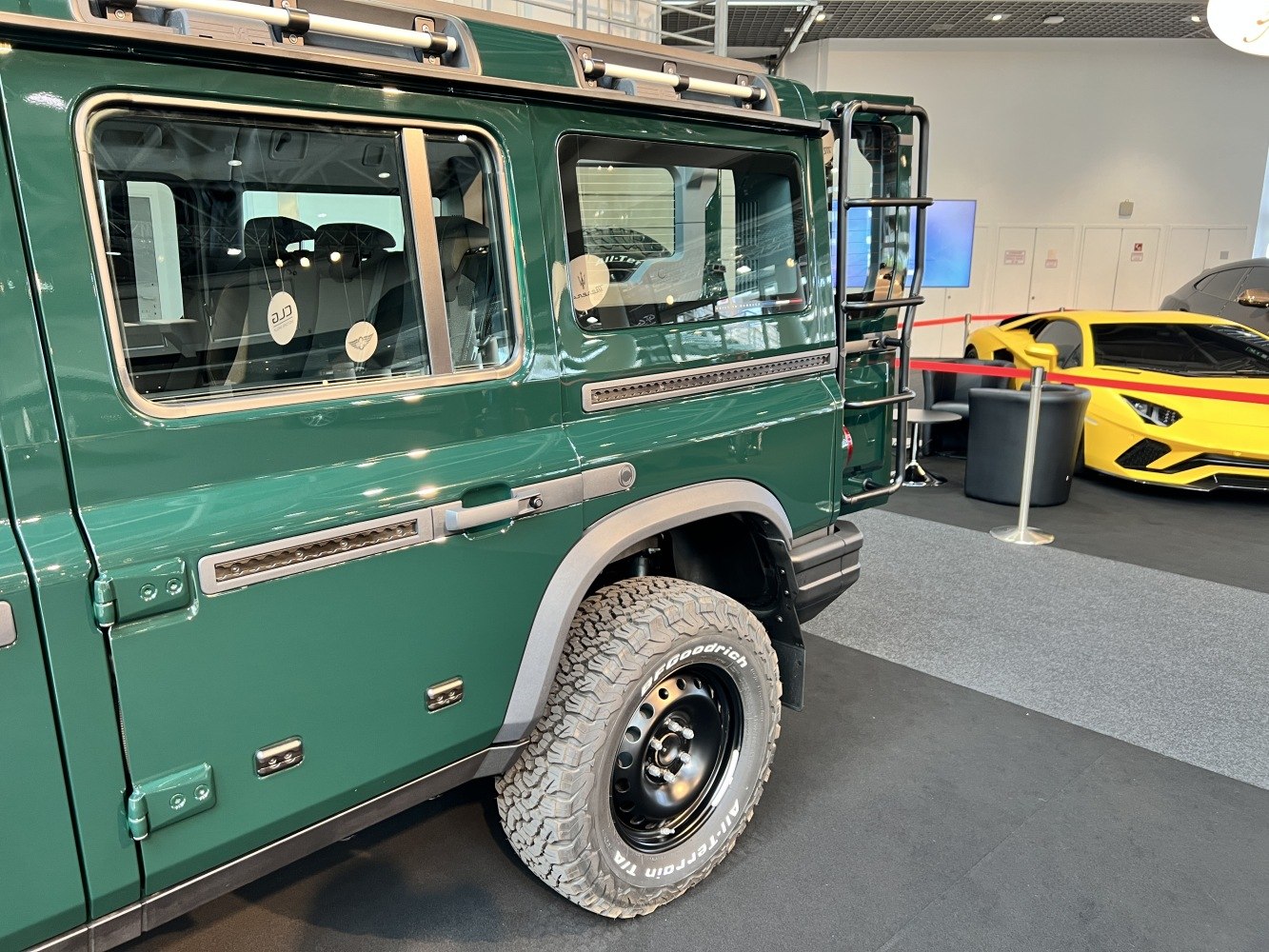 Side view of rugged off-road tire and SUV body with roof rack and rear ladder