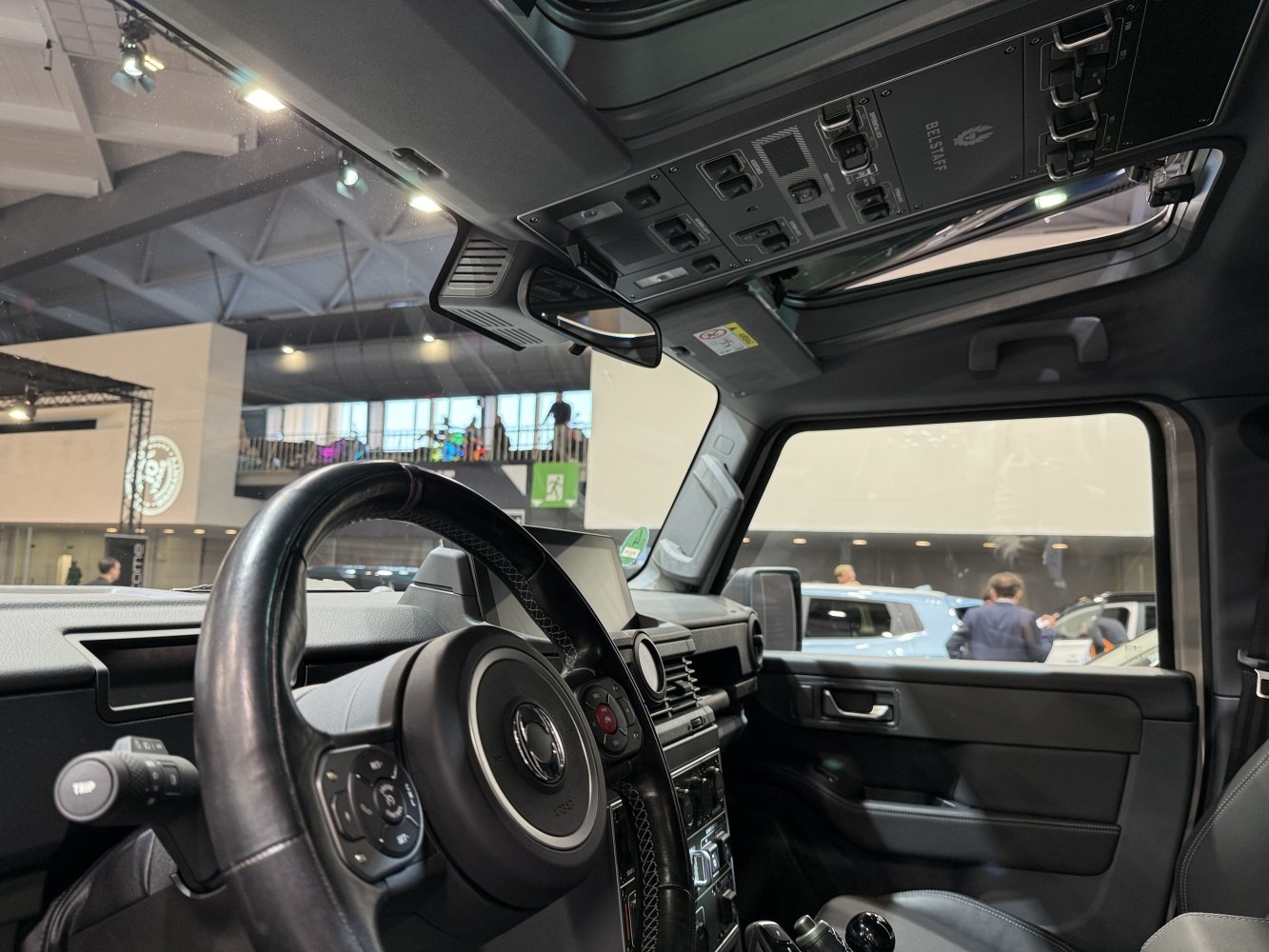Car interior with dashboard, steering wheel, and overhead control panel
