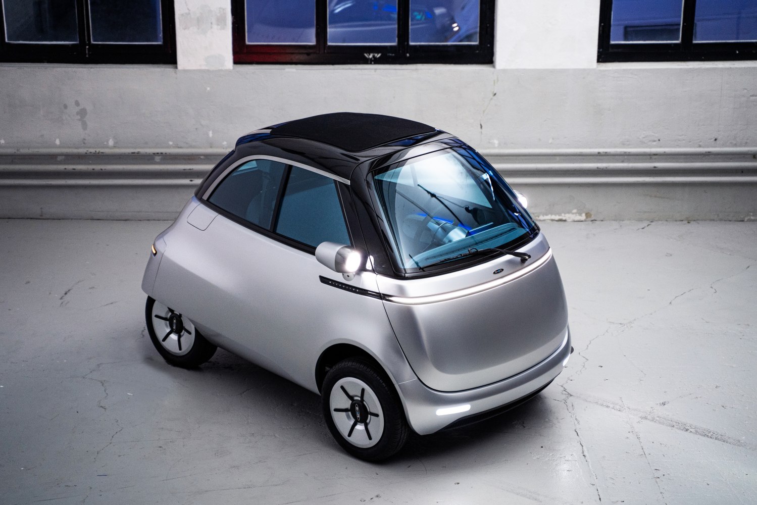 Compact electric vehicle with rounded aerodynamic shape and panoramic windshield