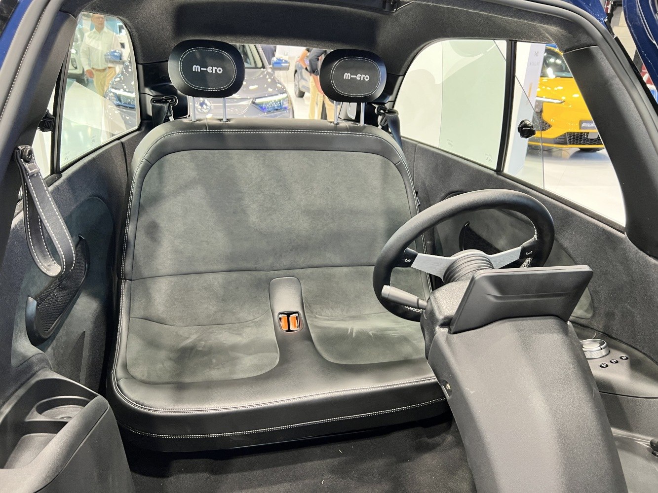 Minimalist interior with bench seat and steering wheel of compact electric vehicle