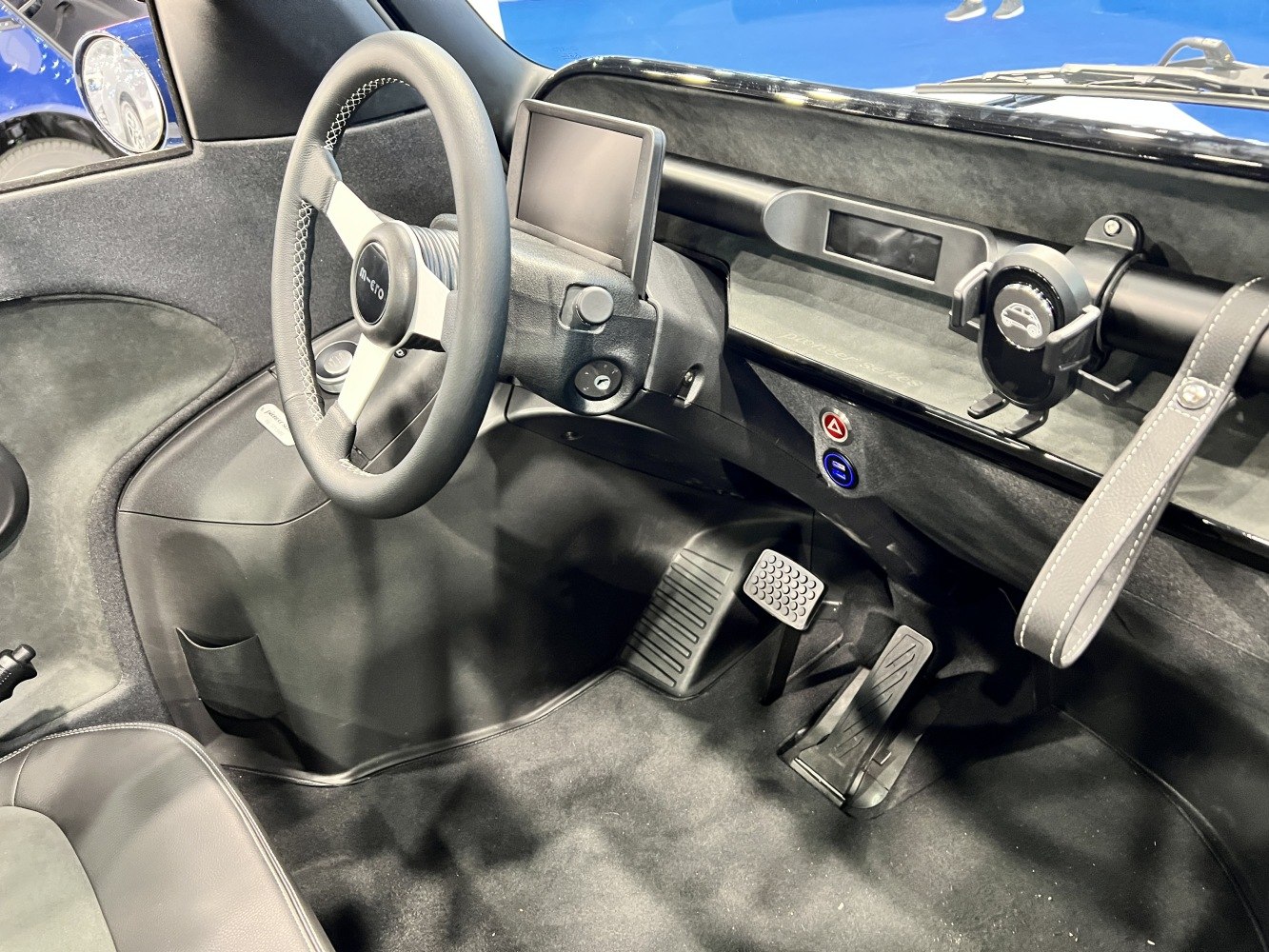 Compact microcar interior with digital dashboard and minimalist controls