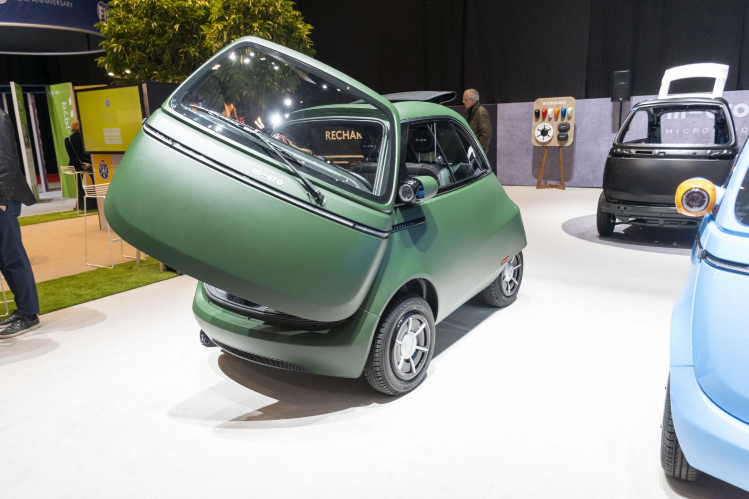 Compact microcar with large front-opening door and rounded body.