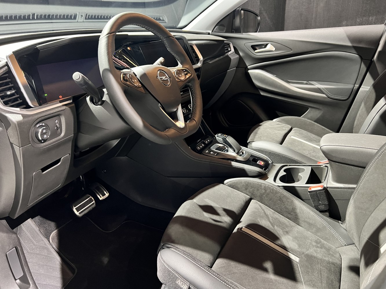 Modern interior featuring dashboard, steering wheel, gear shift, and front seats