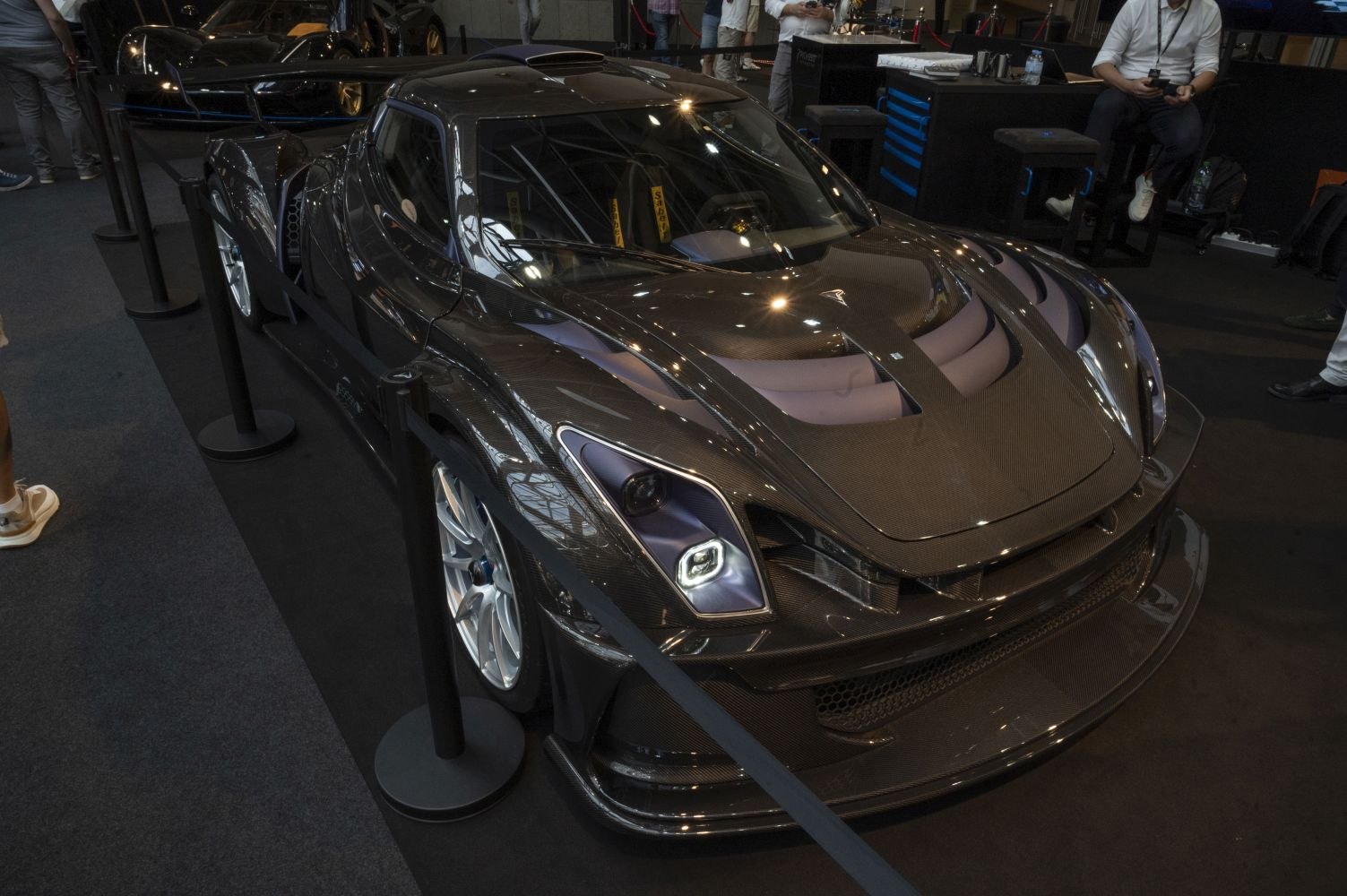 Carbon fiber race car with aggressive aerodynamic design and LED headlights