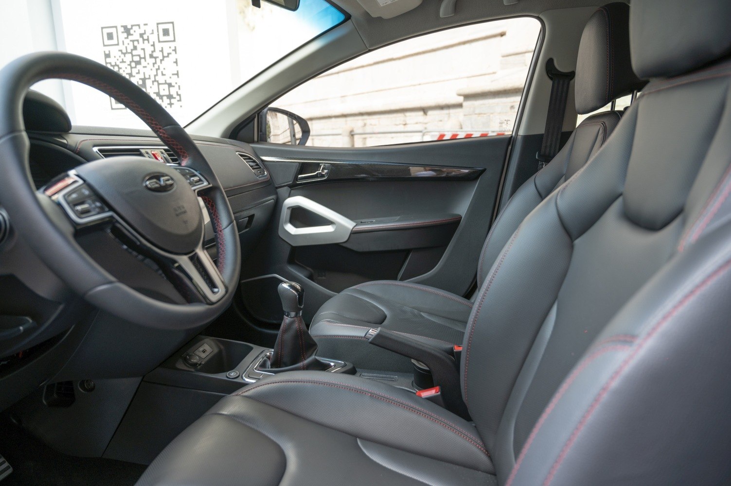 Leather seats with red stitching and manual gear shift interior