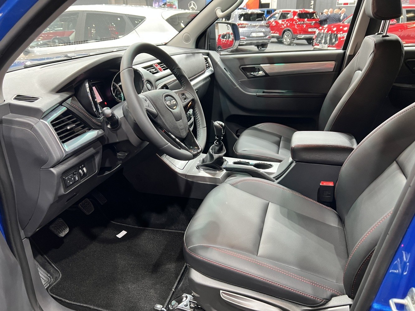 Interior with steering wheel, front seats, and manual gear stick