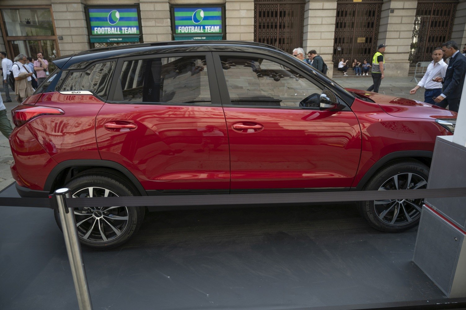 Side profile of a red SUV with black roof and alloy wheels