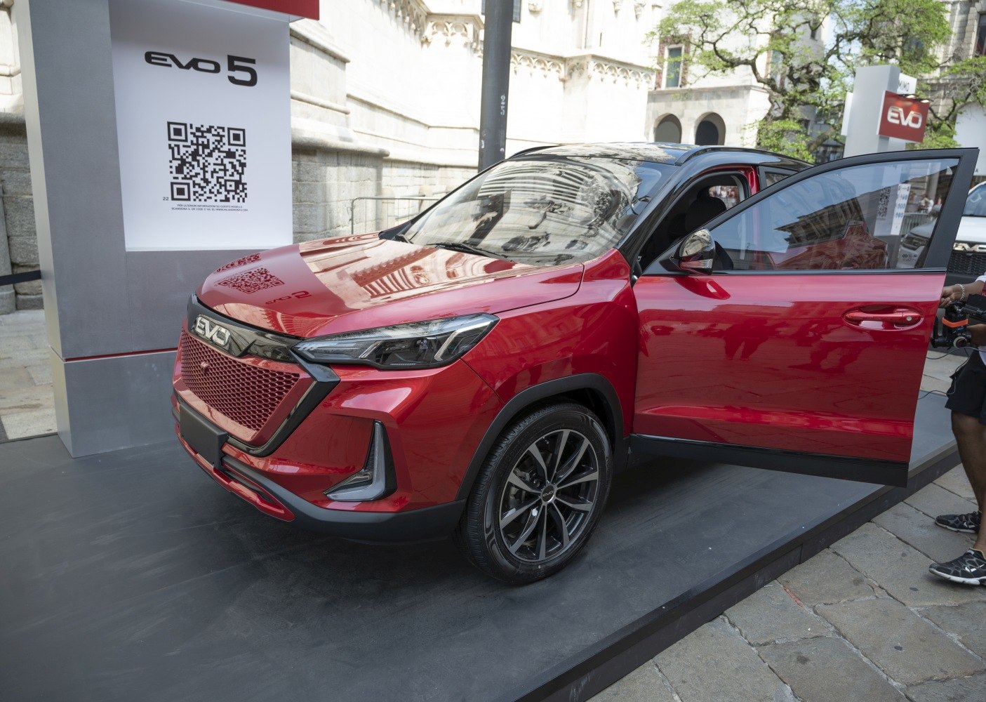 Front-side view of red urban SUV with LED headlights and open driver door