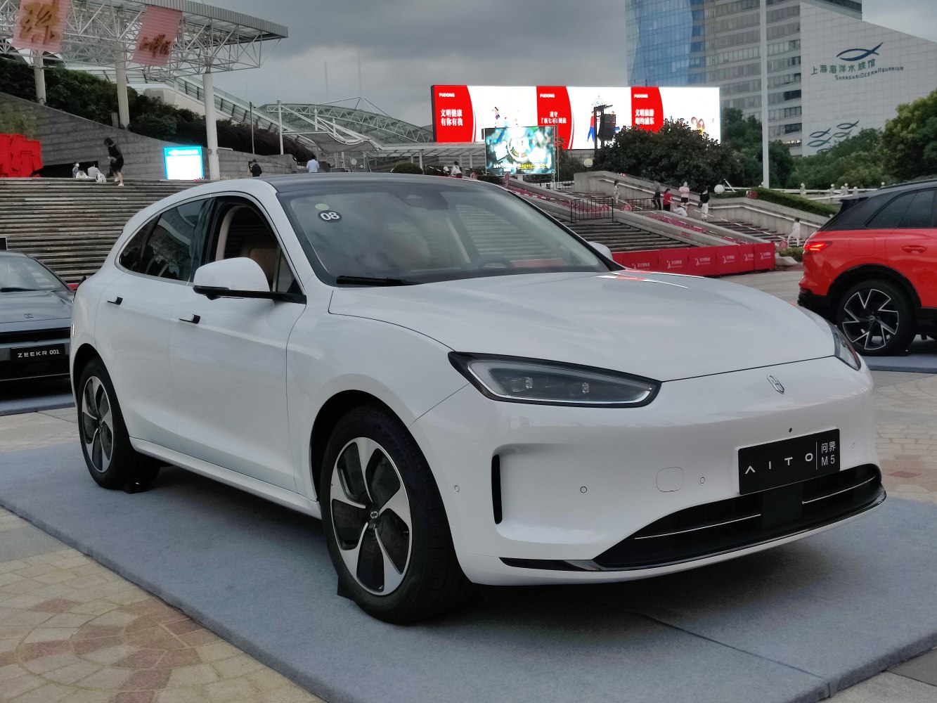 Streamlined white electric sedan with LED headlights and aerodynamic front.