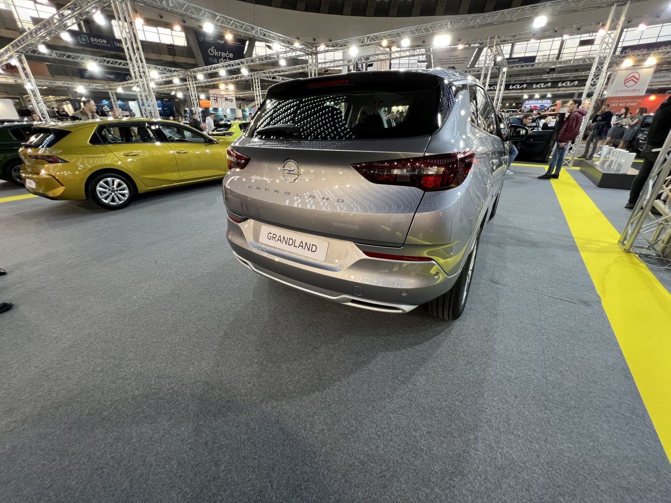 Rear angled view of silver compact SUV with distinct taillights at auto exhibition