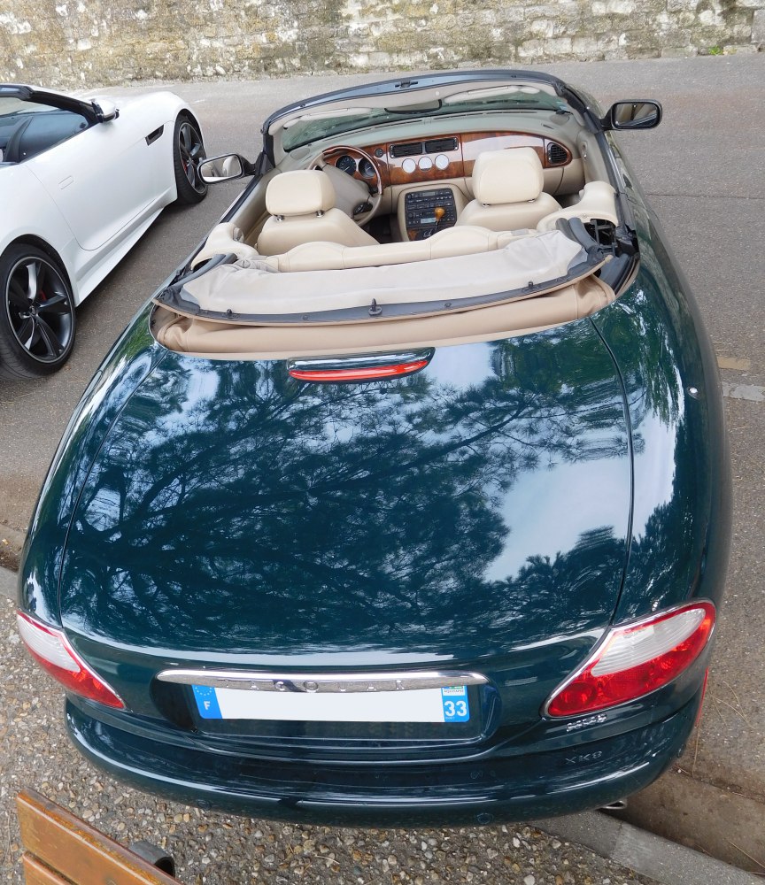 Convertible rear view with beige leather interior and wooden dashboard