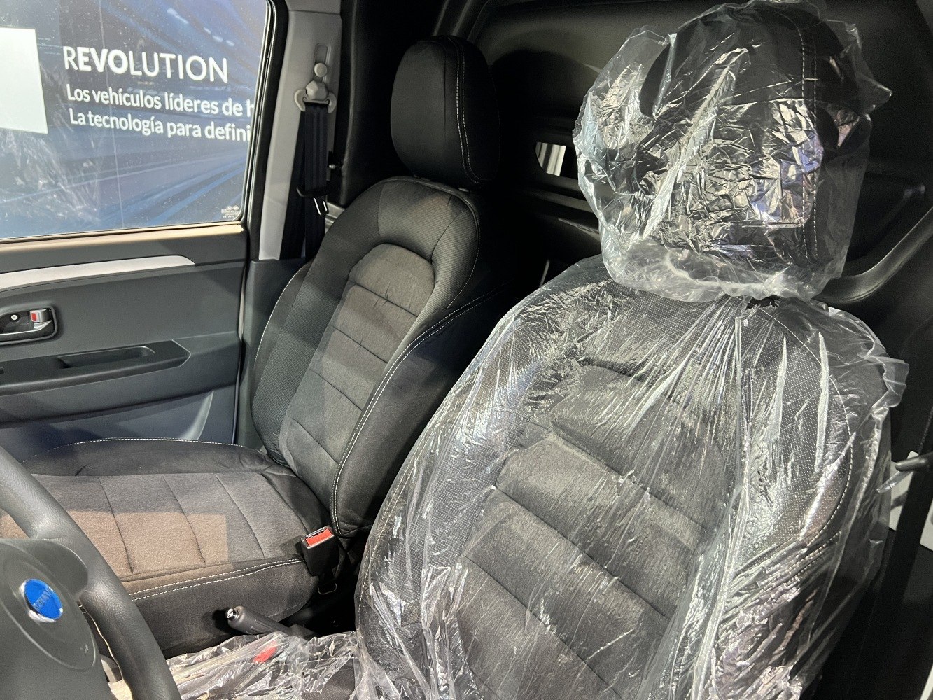 Front seats with protective plastic cover and detailed upholstery stitching