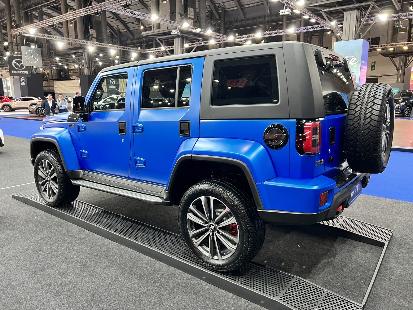 Blue SUV side view with rear spare tire and alloy wheels