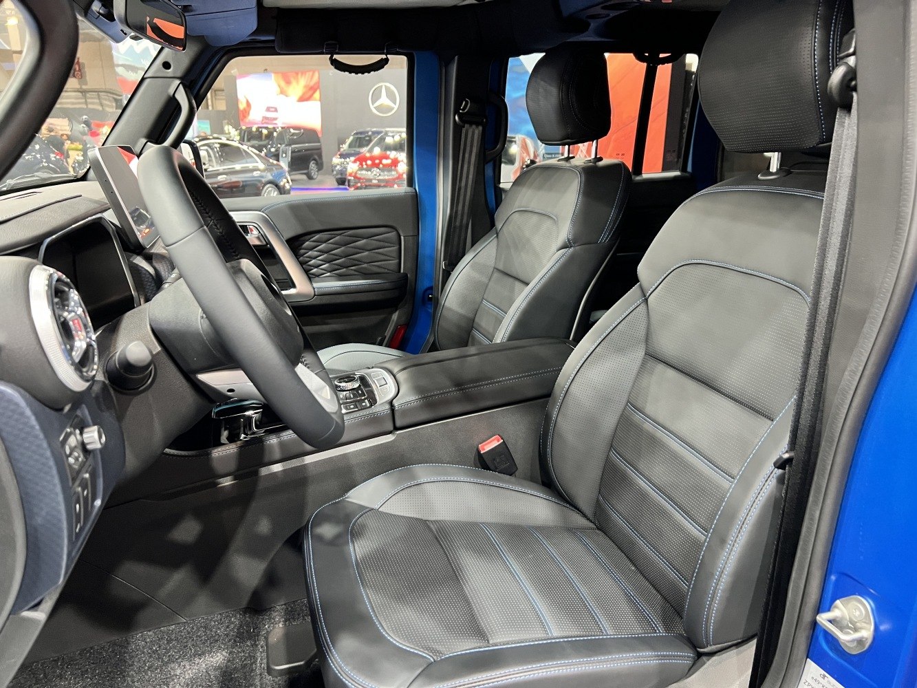 Premium leather seats with blue stitching and modern dashboard design