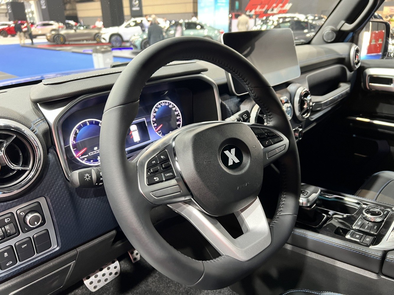 Sporty steering wheel with digital dials and touchscreen display in a modern vehicle interior
