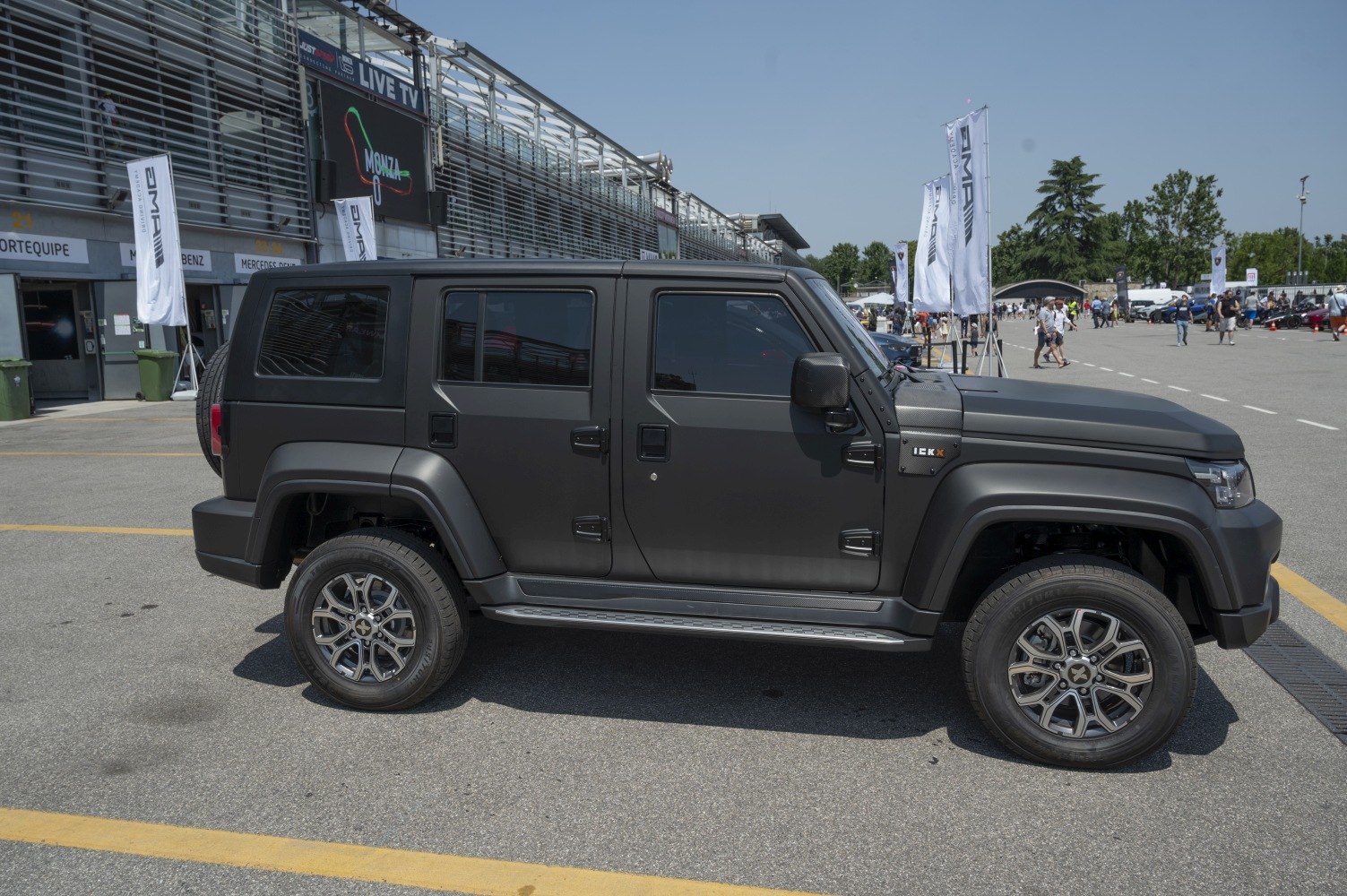 Matte black rugged SUV with four doors and alloy wheels.