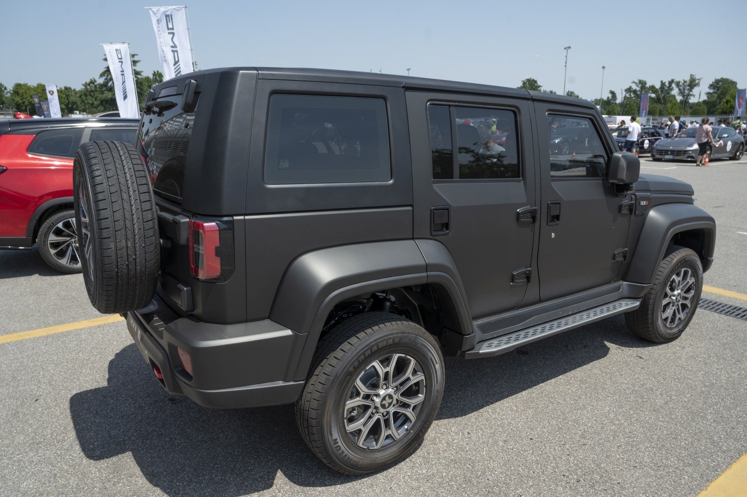 Boxy SUV rear side with mounted spare tire and matte black finish