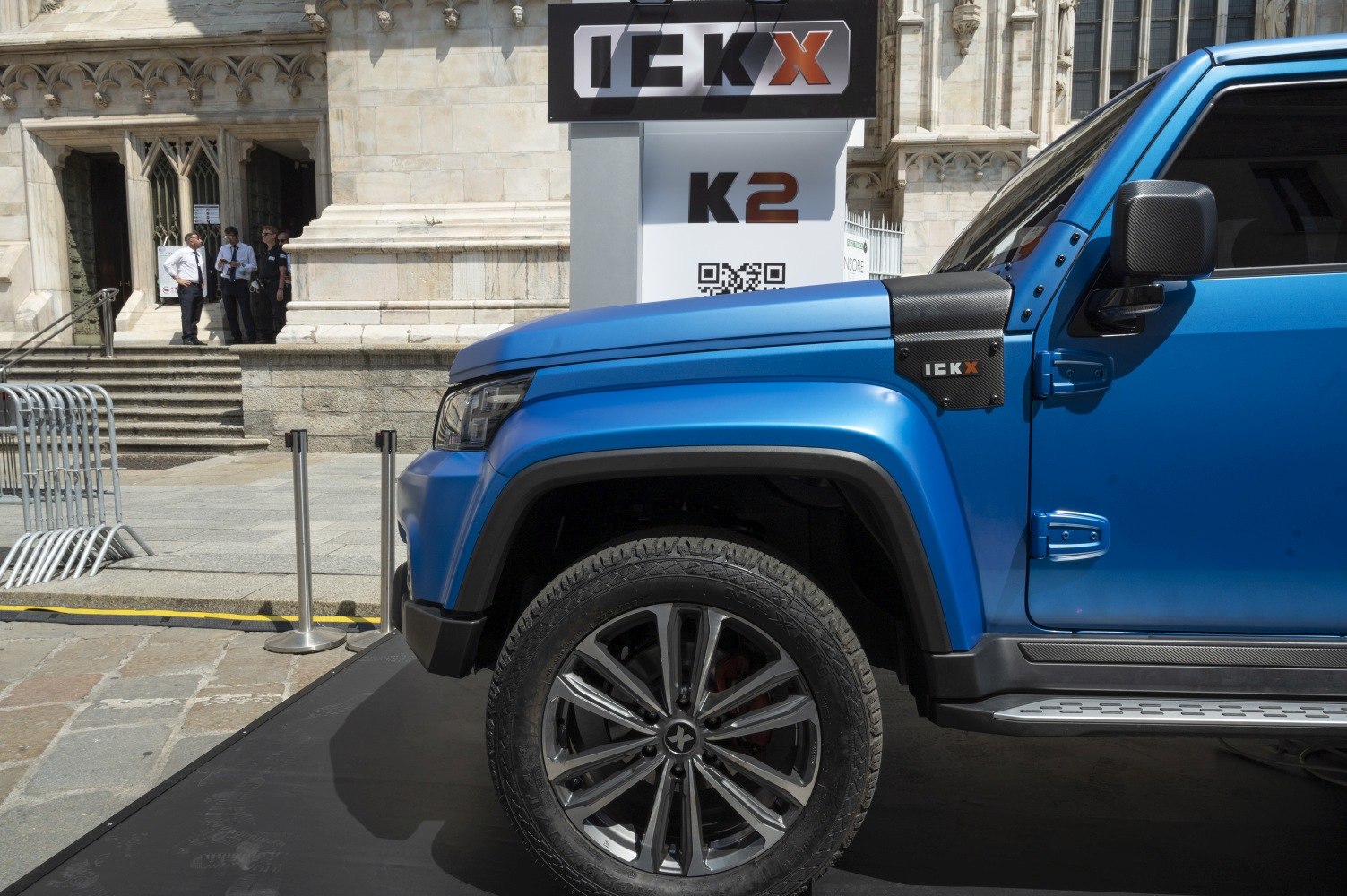 Front side of blue SUV with wheel and carbon fiber fender accents