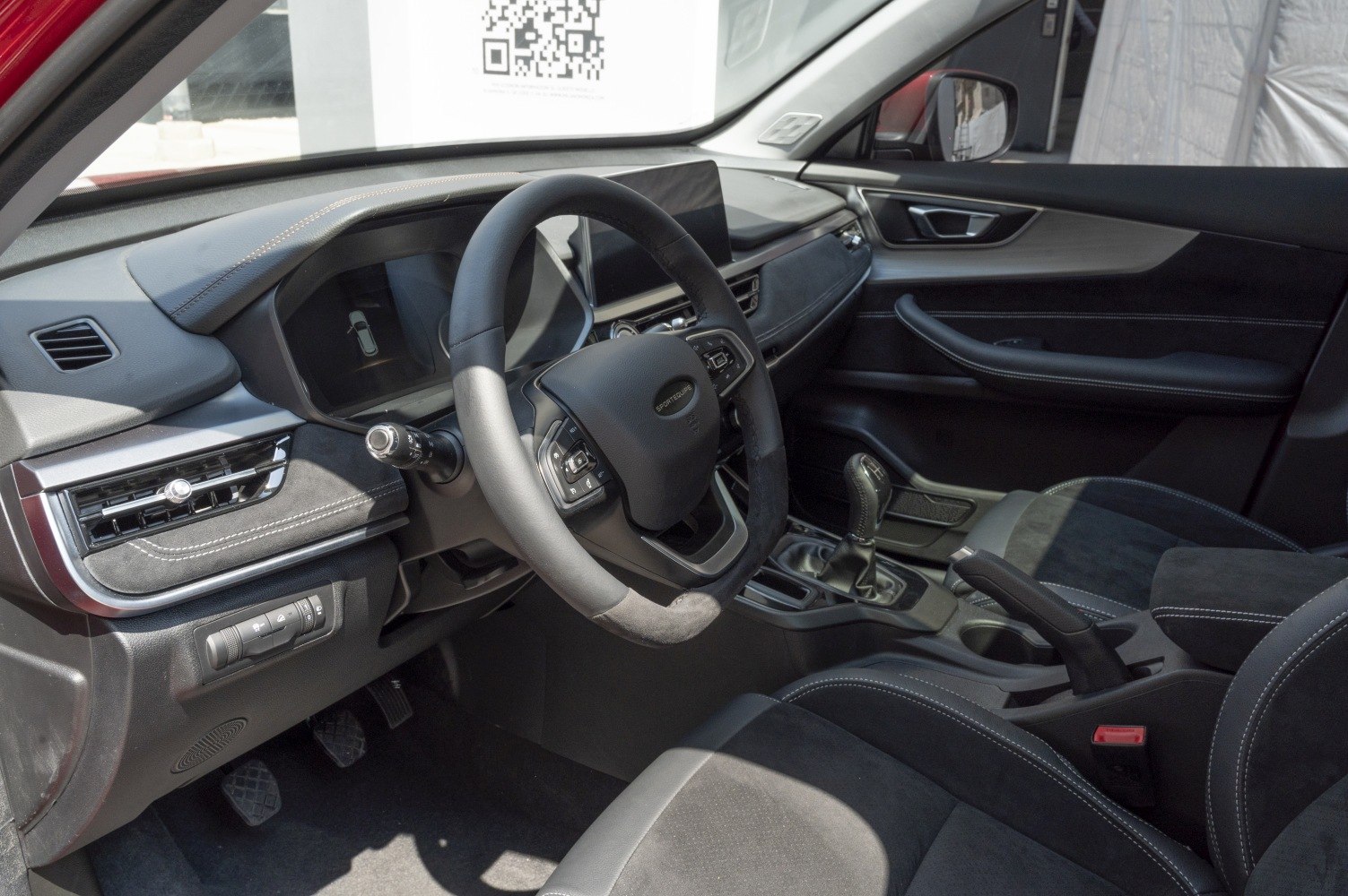 Manual transmission gear stick and multifunction steering wheel in car interior