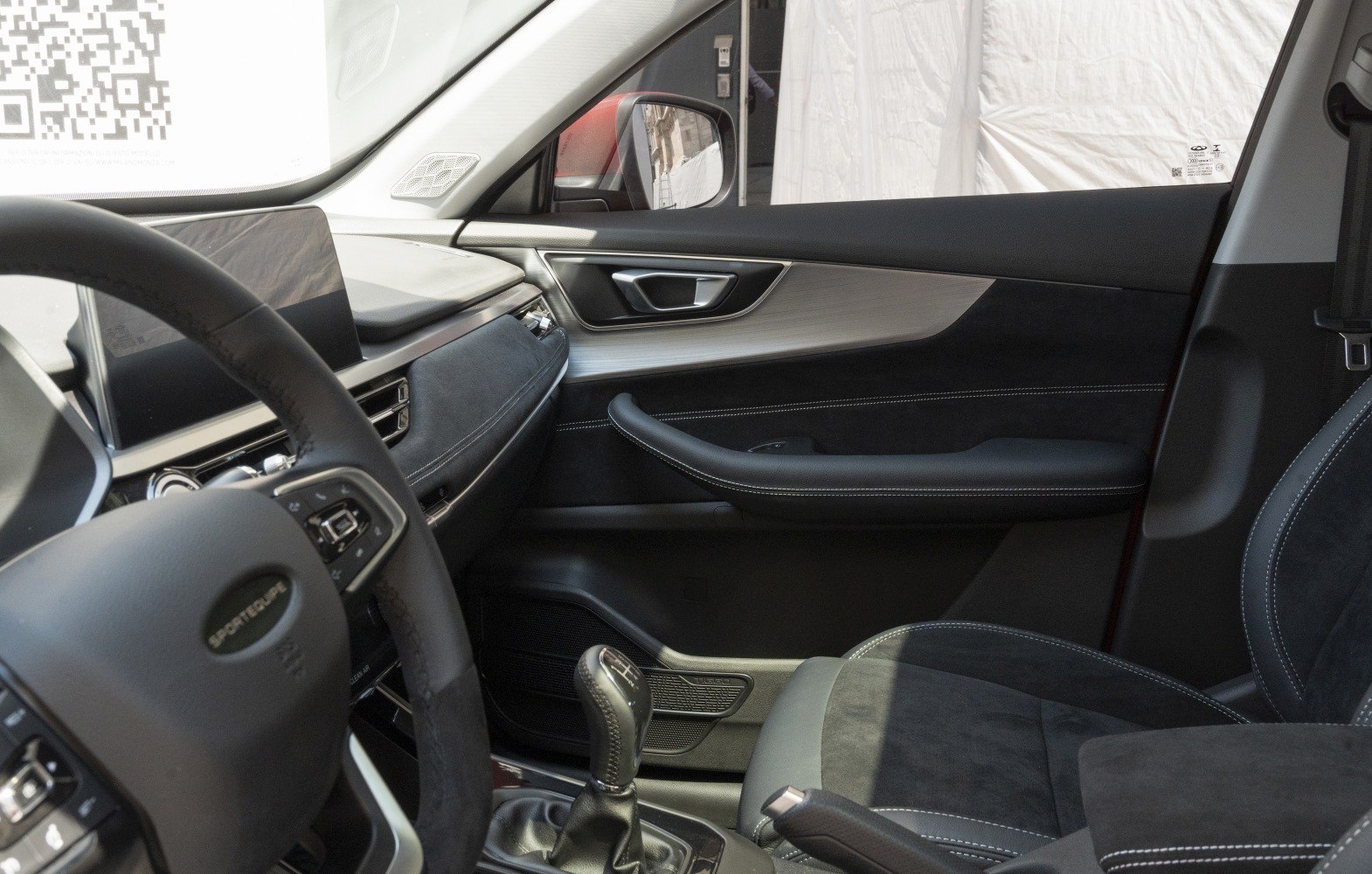 Manual gear shift, digital display, and ergonomic car door interior.