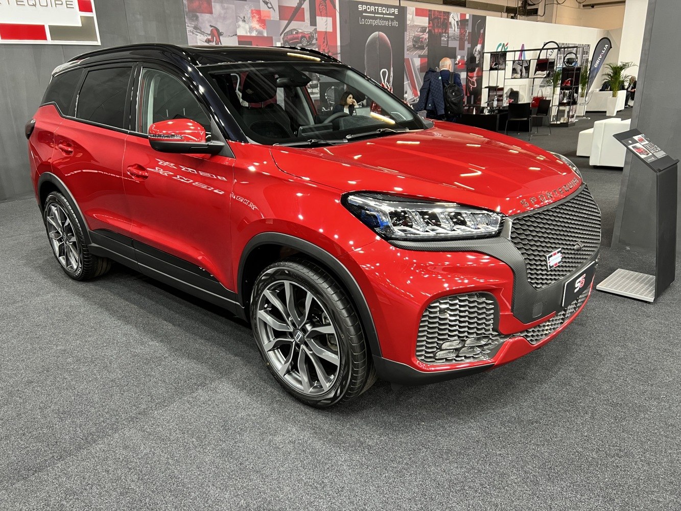 Red SUV with black roof and detailed grille, front-side angle