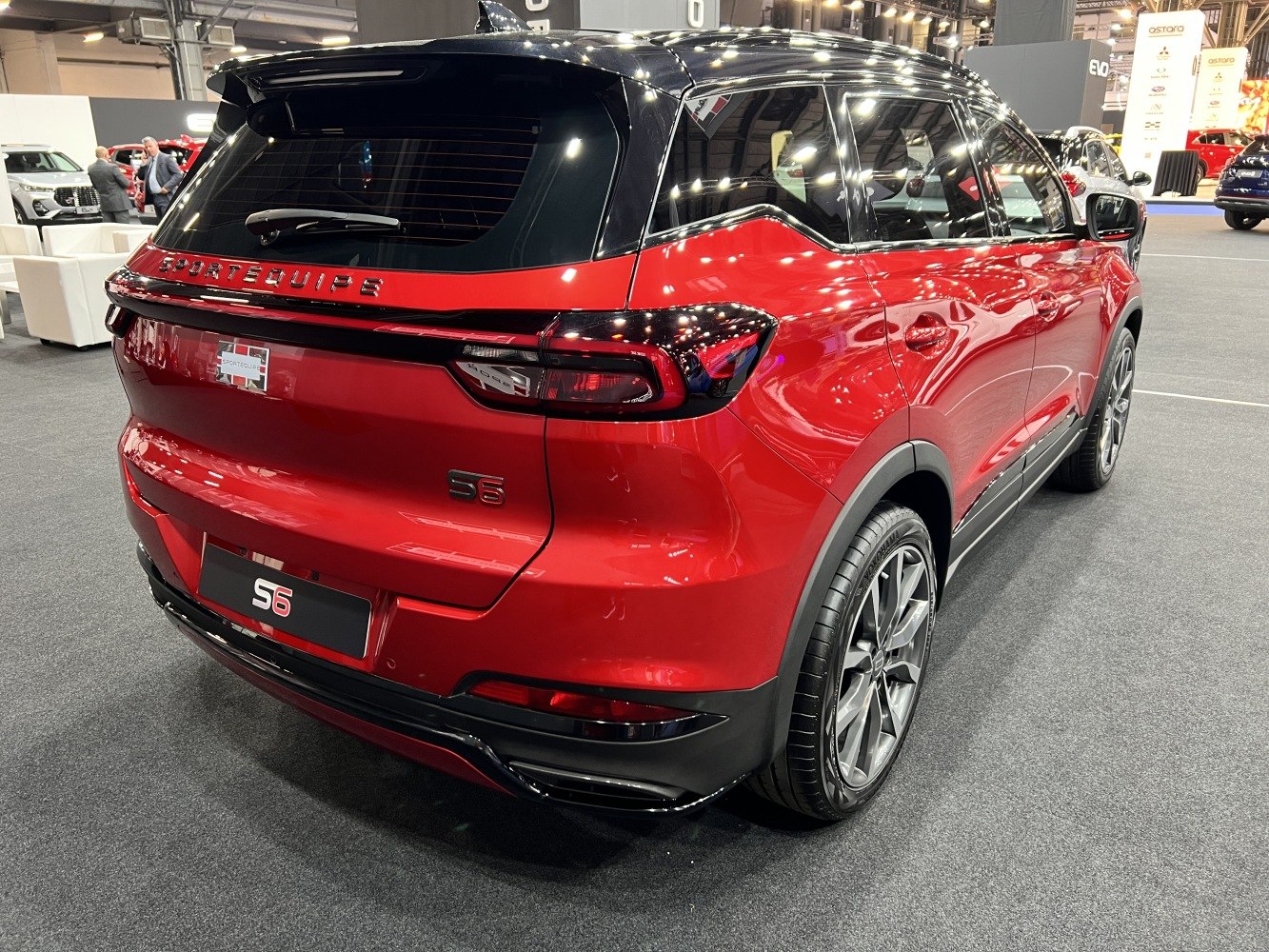 Rear side view of red SUV with sleek tail lights and black roof