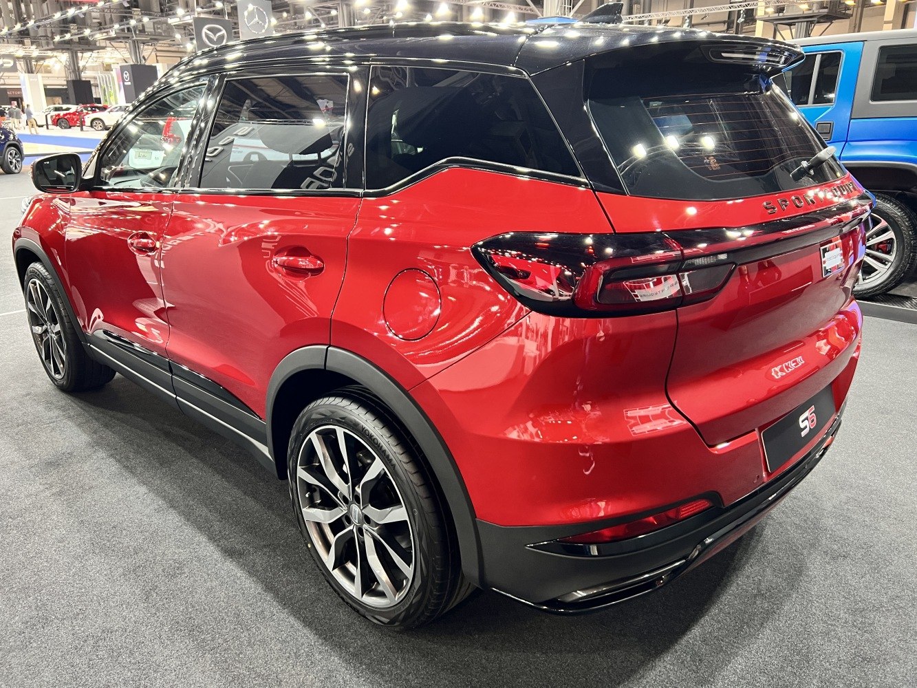Red SUV rear side with black roof and sporty alloy wheels