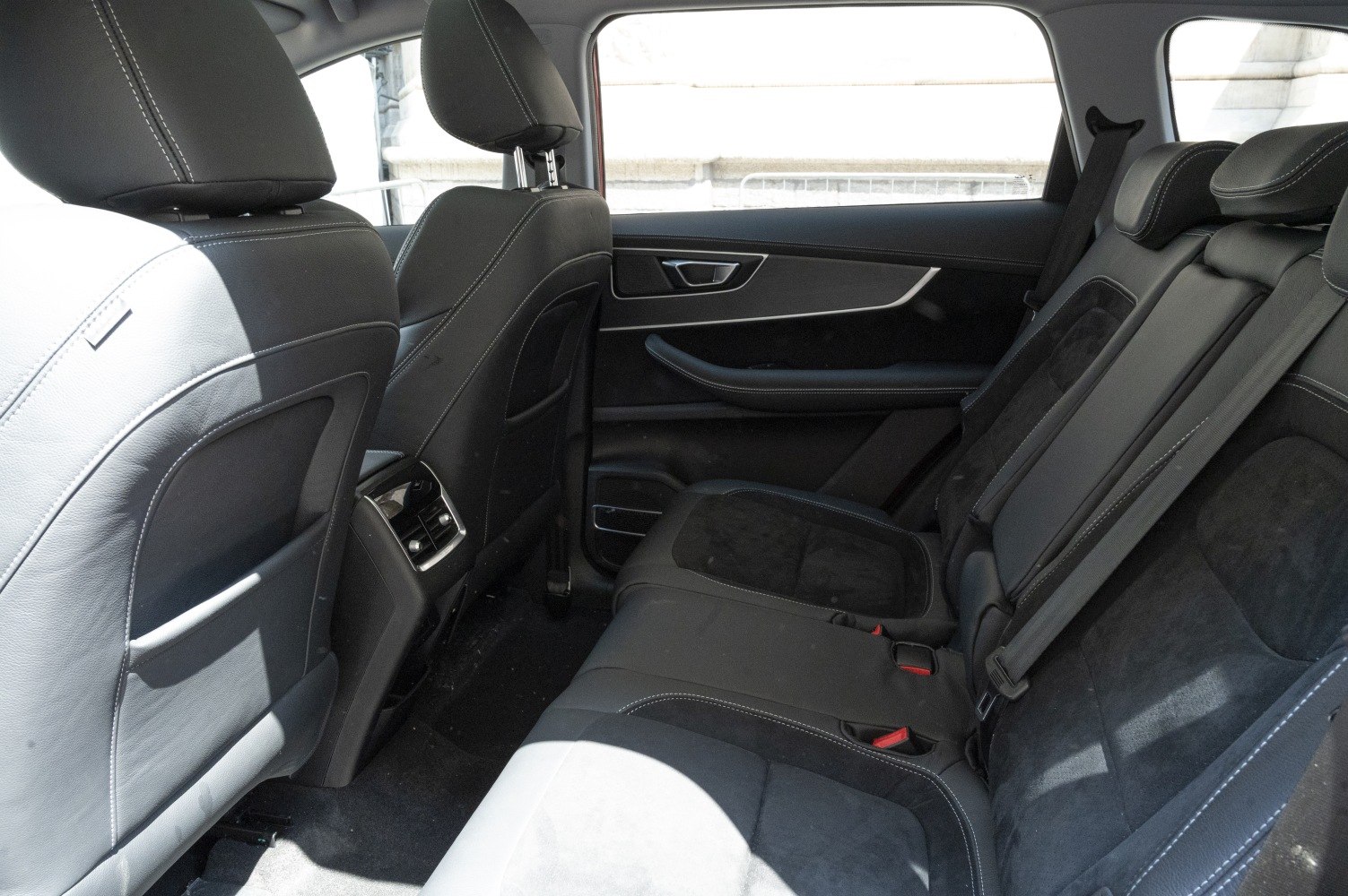 Rear seat interior with black leather upholstery and modern door panel design