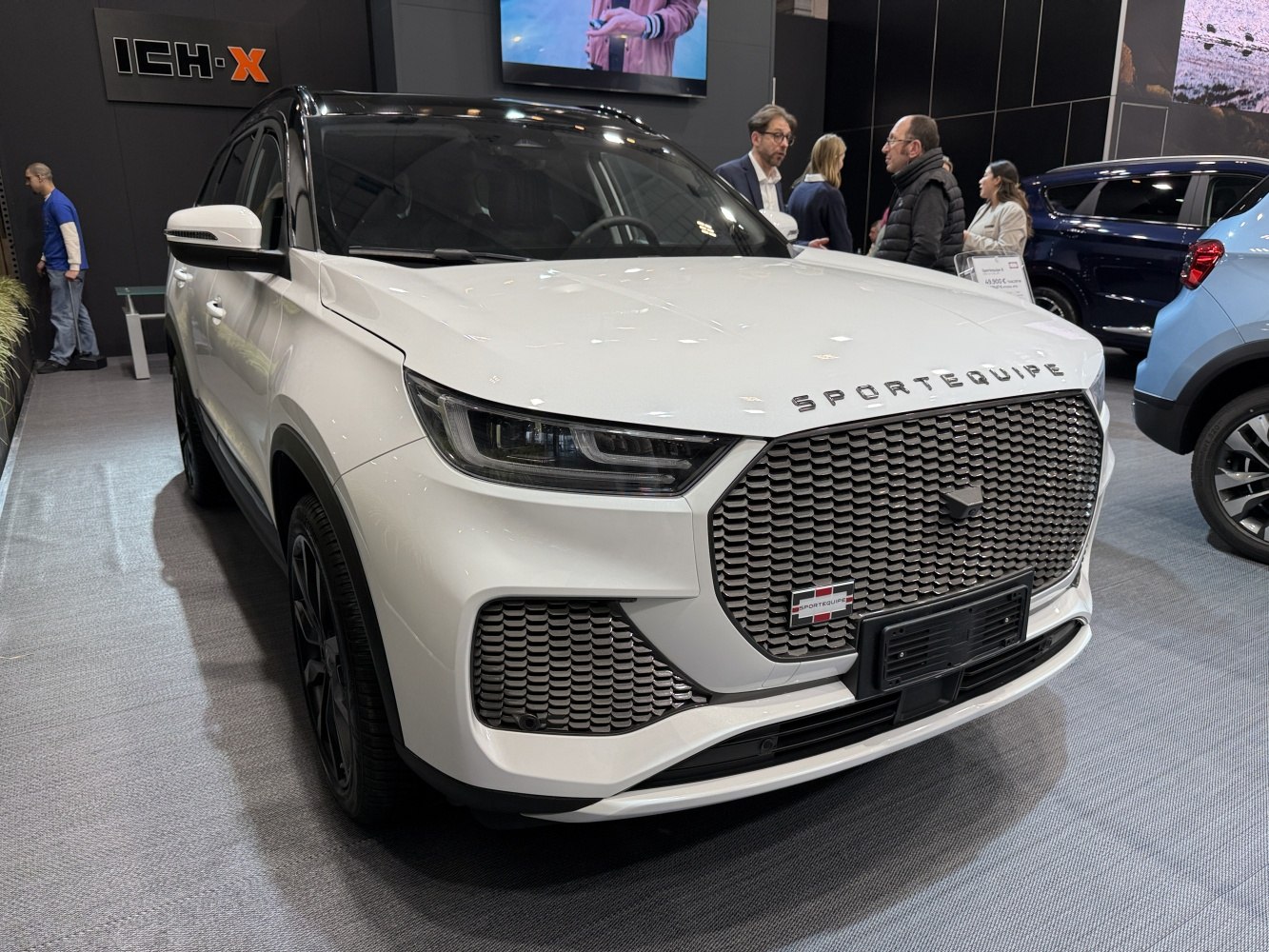 Modern SUV front grille and sleek headlight design in white.