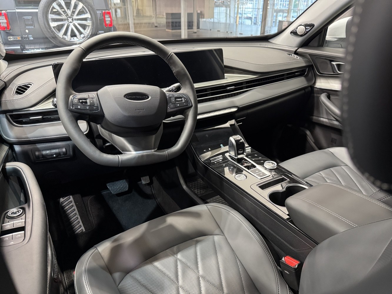 Modern steering wheel and sleek digital cockpit with touch controls.