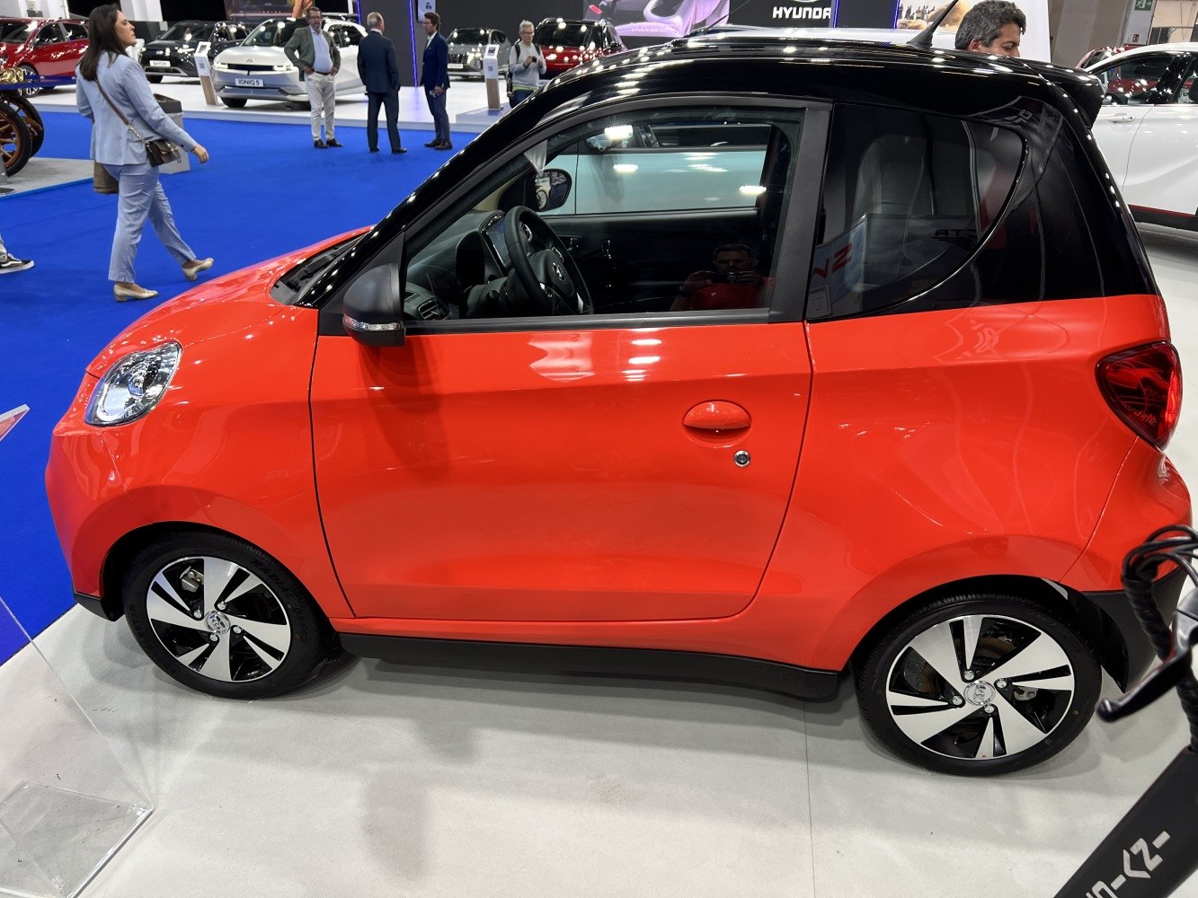 Compact two-door electric car with aerodynamic shape and alloy wheels