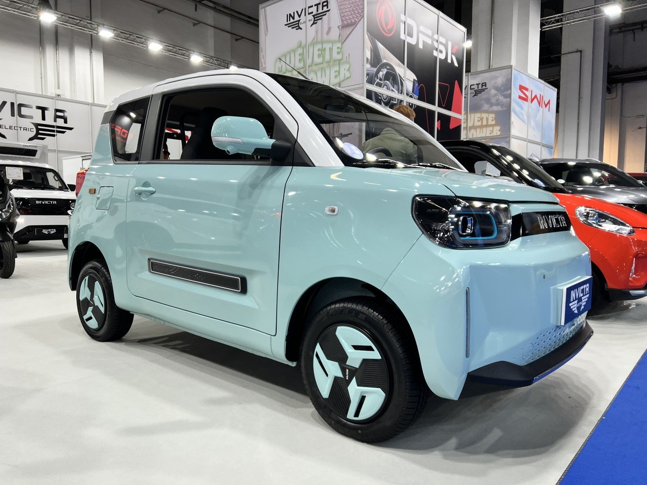 Micro electric vehicle with geometric wheel covers and sleek compact design