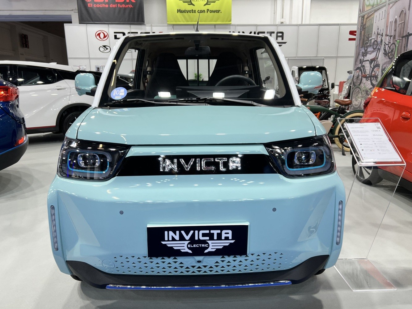 Front view of compact electric vehicle with LED headlights and unique grille