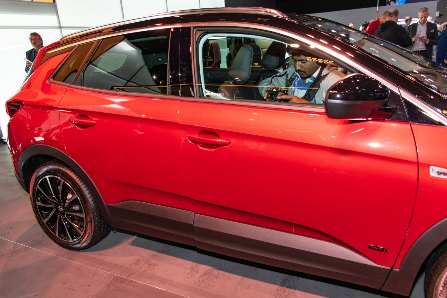 Red SUV side with black alloy wheels and Hybrid 4 badge