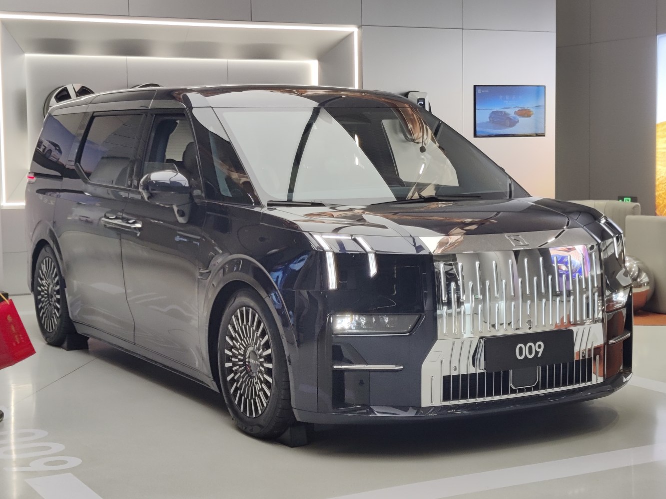 Luxury electric MPV with large chrome front grille and sleek LED headlights