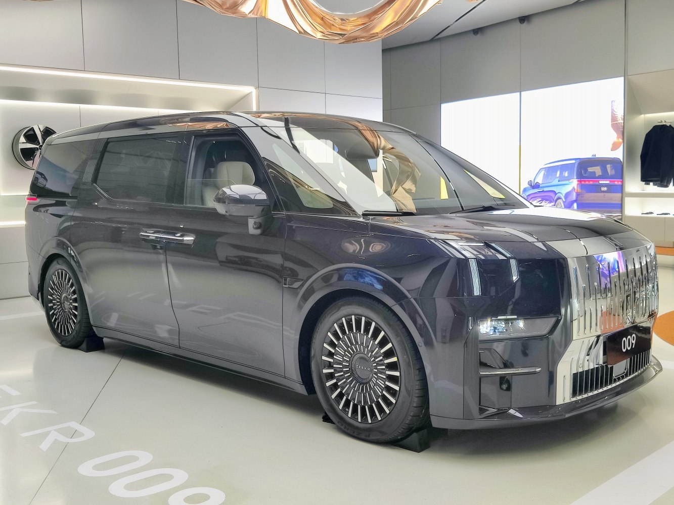 Electric MPV with bold front grille and multi-spoke wheels