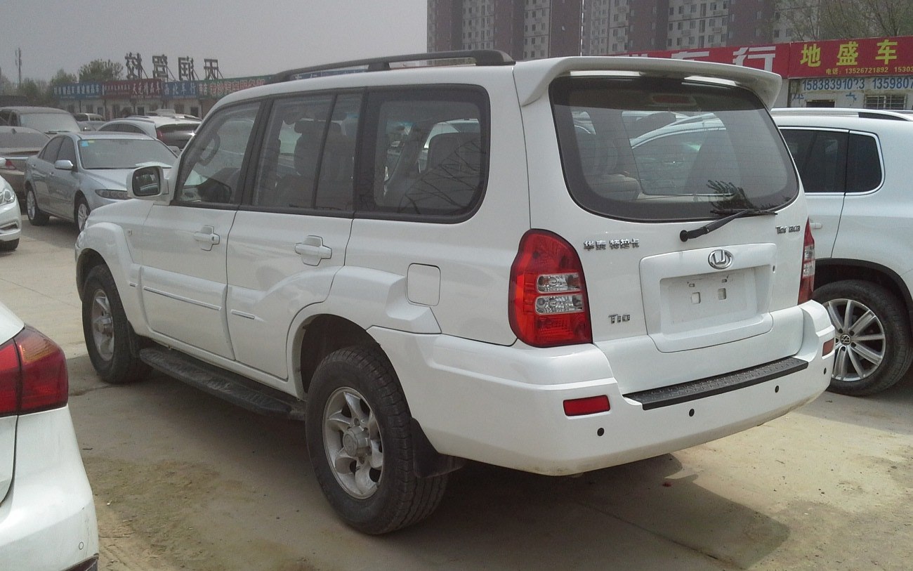 White SUV with rear spoiler, roof rails, rugged tires